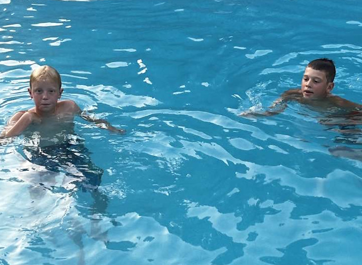 Two boys swimming in a pool