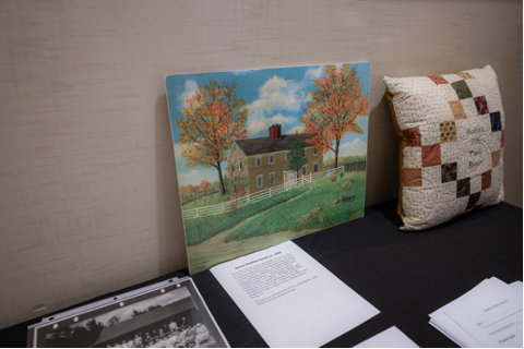 A painting and quilted pillow displayed on a table