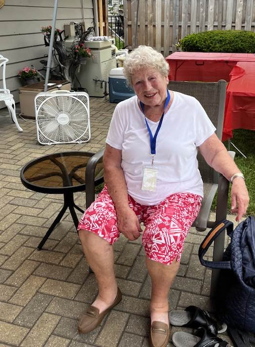 A woman decides to sit out the swimming and relax at a poolside table