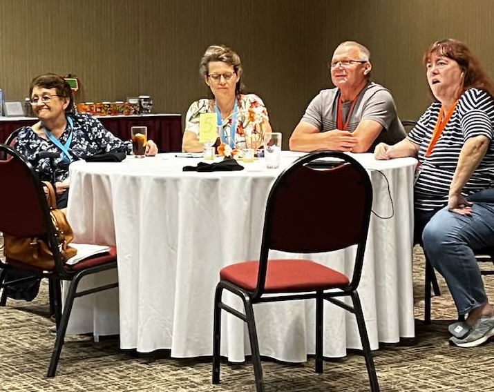 Table with 4 people watching presentation