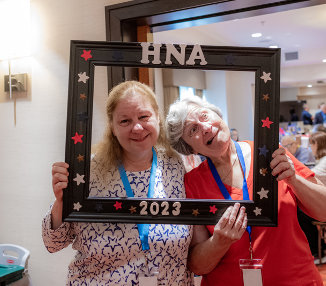 Two more women pose with the frame